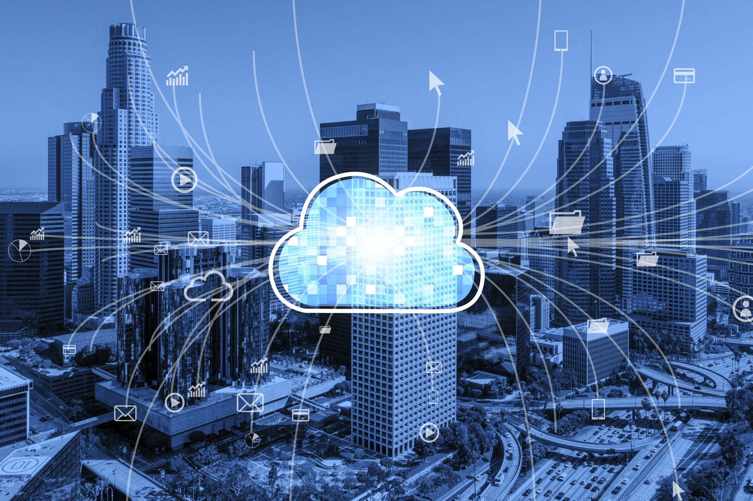 A blue-toned city skyline featuring a central, glowing digital cloud icon. Interconnected white data lines radiate outwards across the skyscrapers to various e-commerce, media, and file icons, illustrating cloud scalability for high-performance online stores. A blue-toned city skyline featuring a central, glowing digital cloud icon. Interconnected white data lines radiate outwards across the skyscrapers to various e-commerce, media, and file icons, illustrating cloud scalability for high-performance online stores.
