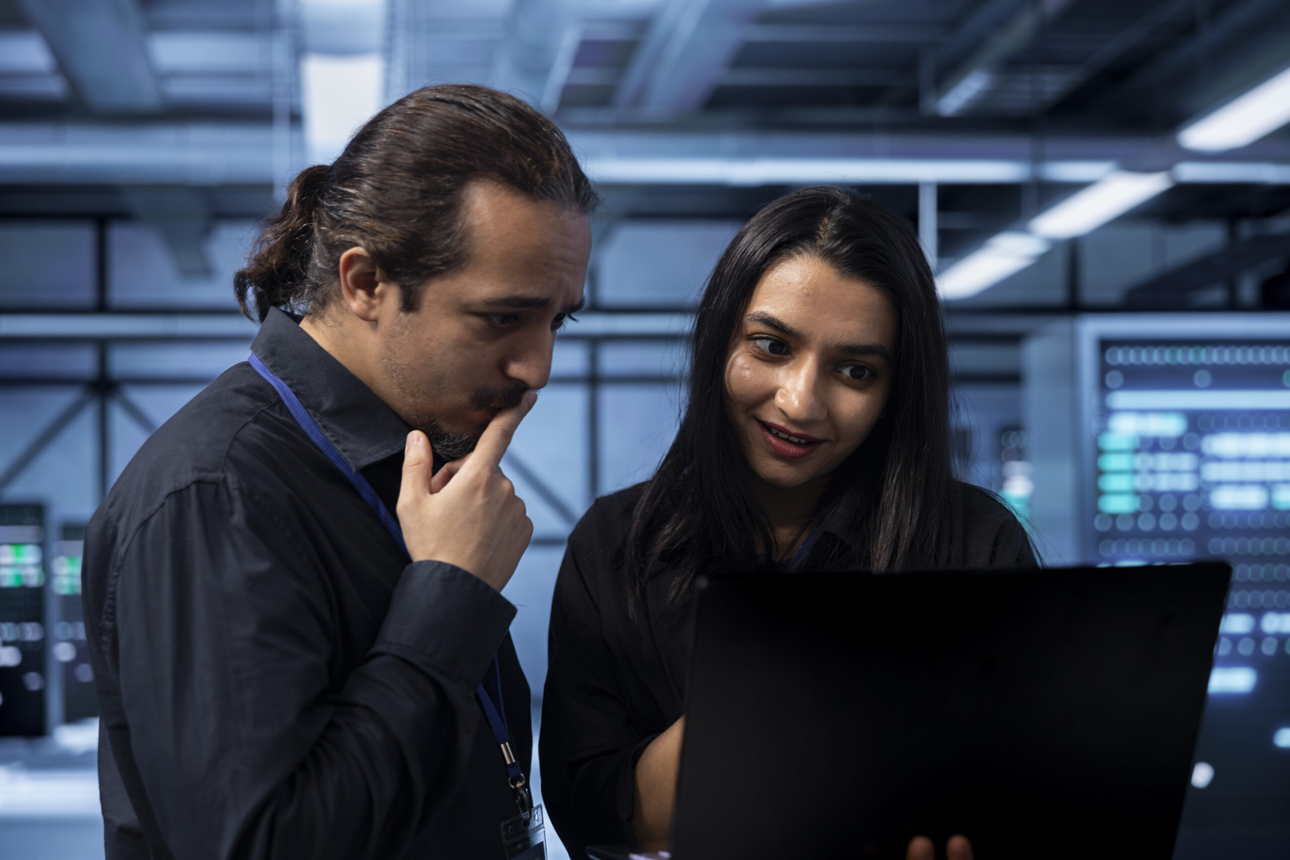 A male and female technician collaborating over a laptop in a high-tech data center, illustrating cloud technology and business infrastructure. A male and female technician collaborating over a laptop in a high-tech data center, illustrating cloud technology and business infrastructure.