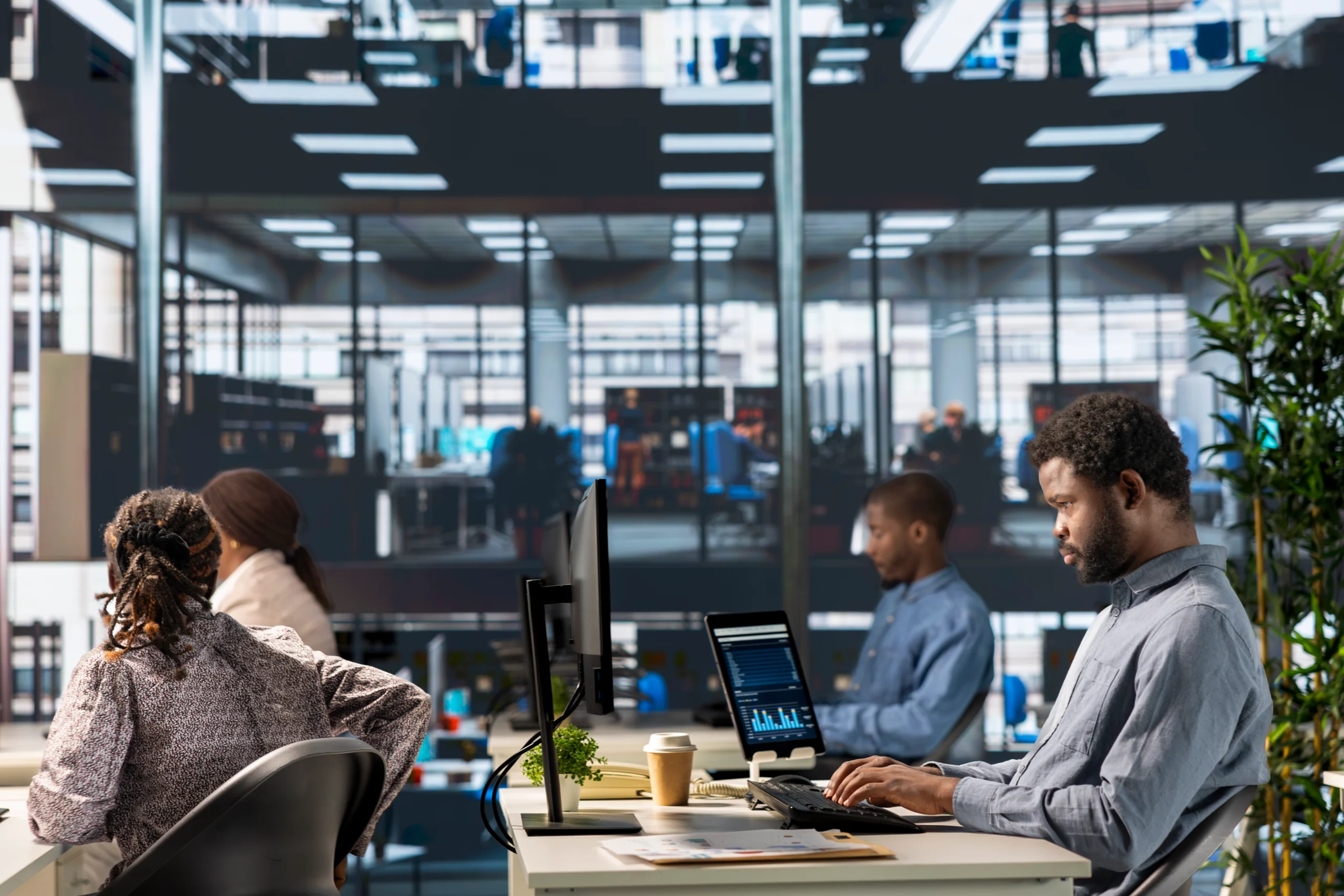 IT and finance professionals working at desktop monitors with cloud cost dashboards in a modern enterprise office, illustrating cloud infrastructure cost management strategies for business leaders.